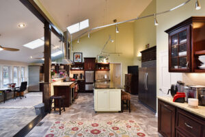 Spacious kitchen with island, dark wood cabinets, stainless steel appliances, and adjacent open dining area.
