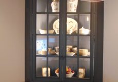 Plates and cups in black China cabinet