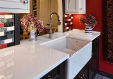 Kitchen with large sink and red, white, and grey backsplash